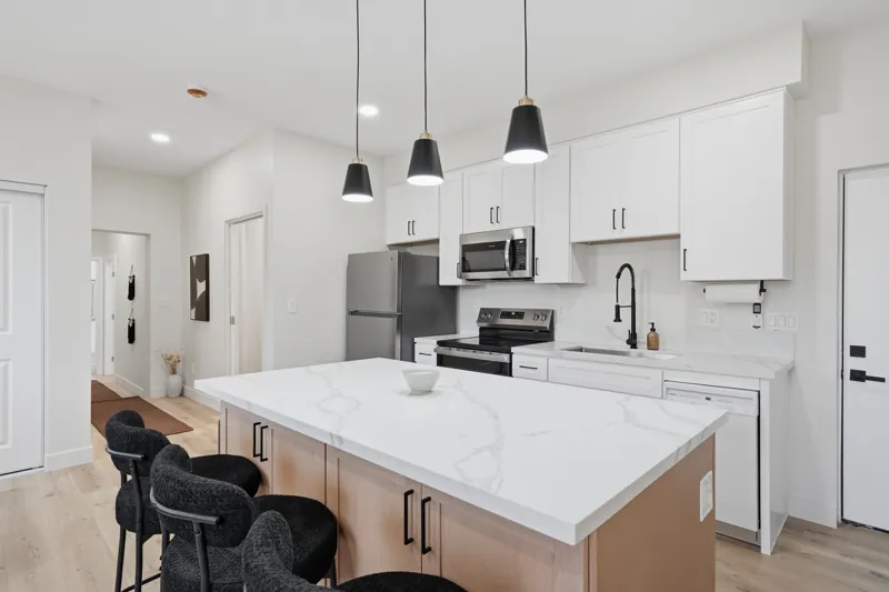 White kitchen with an island and pendant lights