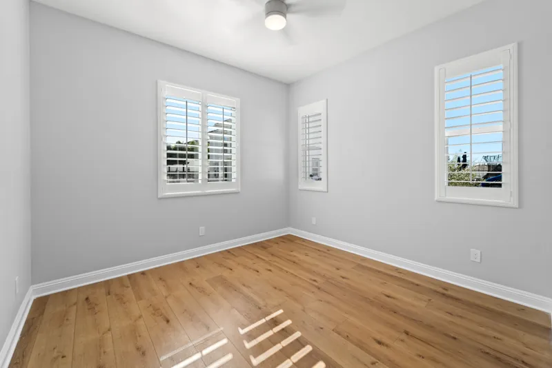 Bedroom with wood flooring and shuttered windows